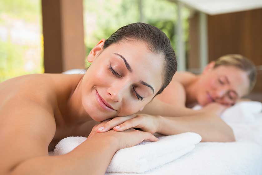 Friends lying on massage tables