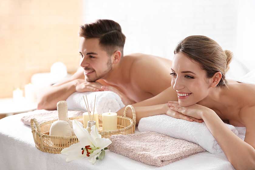 Young couple with spa essentials in wellness center